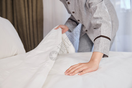 酒店管理保洁员整理床铺特写图片