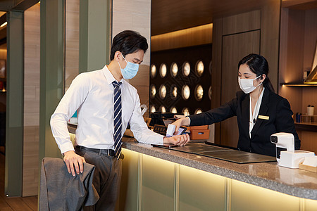 酒店前台服务人员给顾客测量体温酒店服务高清图片素材