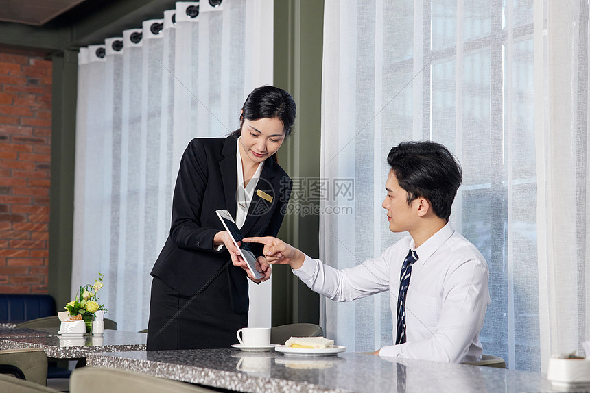 酒店餐饮区的服务人员给顾客点餐图片