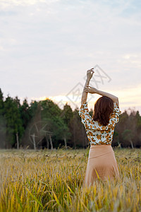 夕阳下的女性背影女性享受田野大自然背影背景