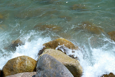 海浪拍打着石头和蔚蓝的海水图片