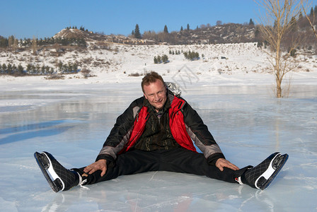骑冰鞋后在冰上休息的人图片