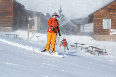 在暴风雪中下坡的滑雪板女孩图片
