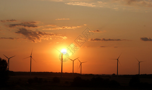 在日落期间的风力涡轮机图片