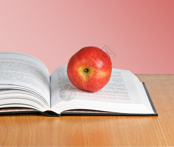 打开书本上的红苹果背景图片