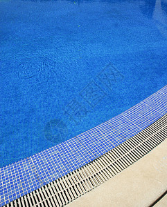 游泳池蓝色水在一个夏日背景图片