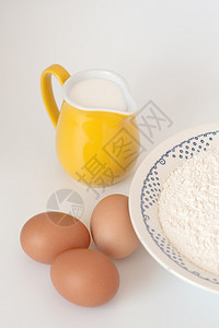 白色背景上的牛奶鸡蛋和面粉罐图片