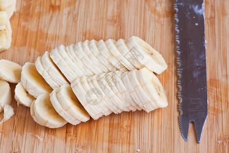 木板上新鲜切好的香蕉和刀图片