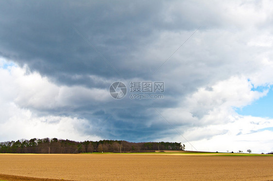 田野上空的乌云和蓝天图片