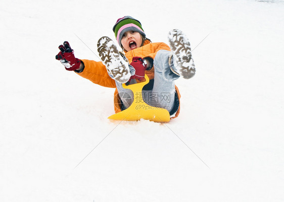 女孩在下雪时滑雪从山上滑下来图片