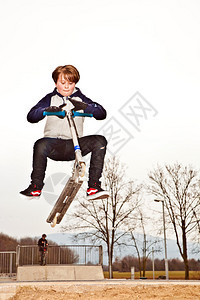 男孩在滑板公园上骑摩图片