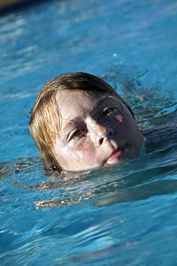 快乐的孩子在游泳池里游泳图片