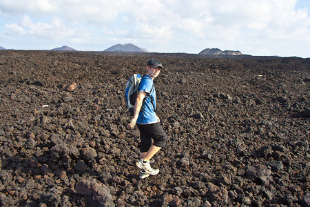 男孩在兰萨罗特岛火山区的步行道上图片