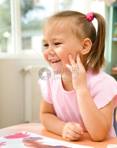 可爱的小女孩在幼儿园玩颜料图片