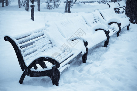 冬季公园的白雪覆盖的长椅图片