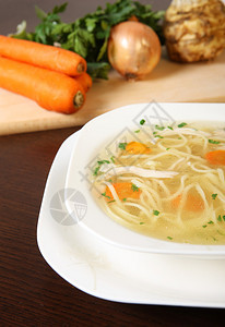 一碗传统鸡汤的图片在一个碗里供应过蔬菜背图片