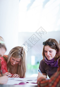 一群大学生大学生在课间休息聊天比较笔记玩得开心图片