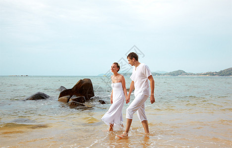 泰国普吉岛海滩穿着白棉服装的年轻情侣户外肖像画图片