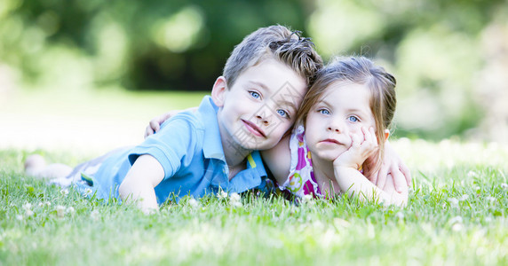两个孩子躺在草地上拥抱图片