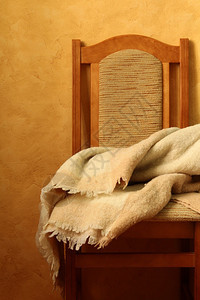 棕色背景上带毯子的椅子图片