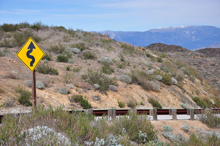 警告南加利福尼亚州沙漠公路前方有弯图片