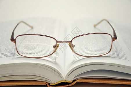 放时尚眼镜的厚书背景图片