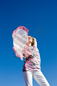 快乐的年轻女士带着围巾在海图片