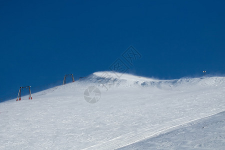 一张在阿拉斯加安克雷奇附近寒冷多风的日子里滑雪缆车的照片那是一个阳光明媚的日子图片