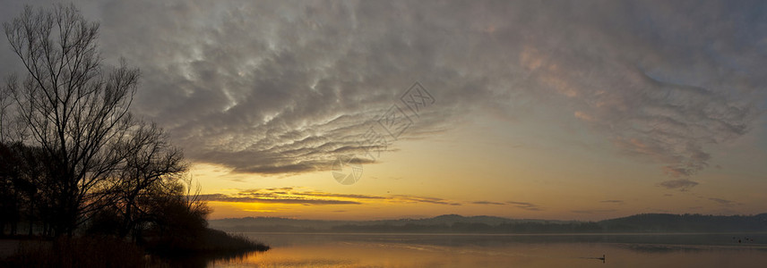 湖边寒冷的冬日早晨黎明的温暖色彩图片