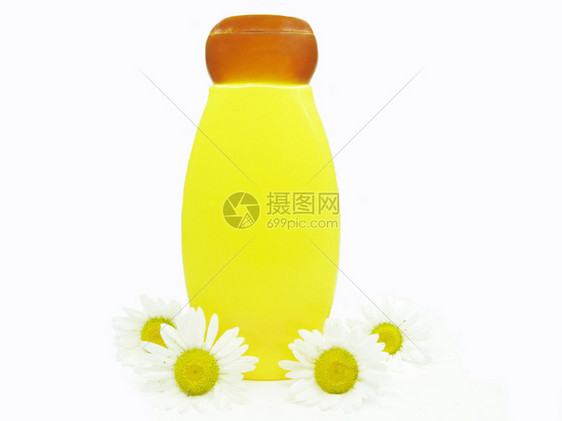 黄色花卉瓶与雏菊精华的草本洗发水图片