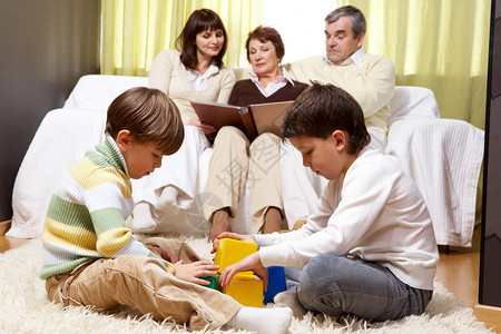 祖父母和亲的家庭坐在沙发上读书图片