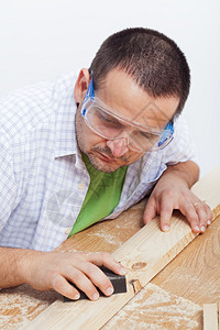用砂纸手工打磨木板的人图片