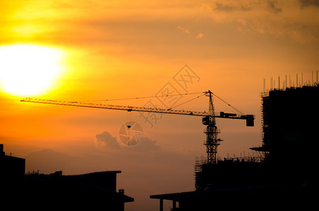 工业建筑起重机和日落的建筑剪影图片