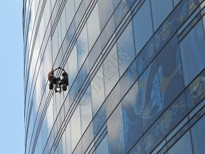 Steeplejack洗摩天大楼的玻璃墙背景图片