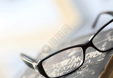 现代眼镜和旧书图片