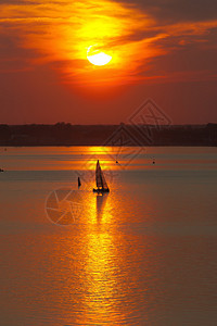 日落时海中的帆船剪影图片