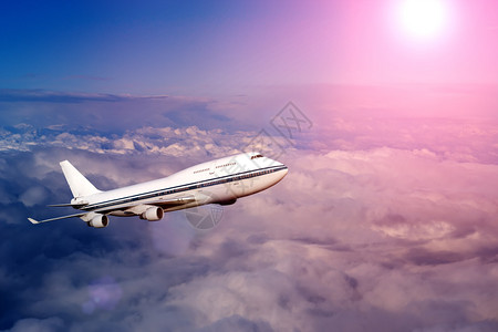 日落或黎明时分在云层中的客机乘坐航空运输飞到客机的图片