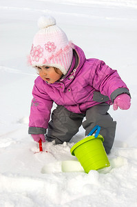 小女孩玩雪铁锹和桶图片