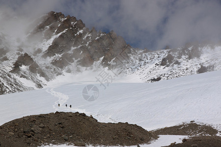 穿过山谷的狭小通道云中山峰冰川上的观光图片