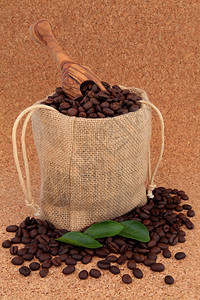 咖啡豆装在海珊麻布袋里叶子松了橄榄和橄榄木的勺子压图片