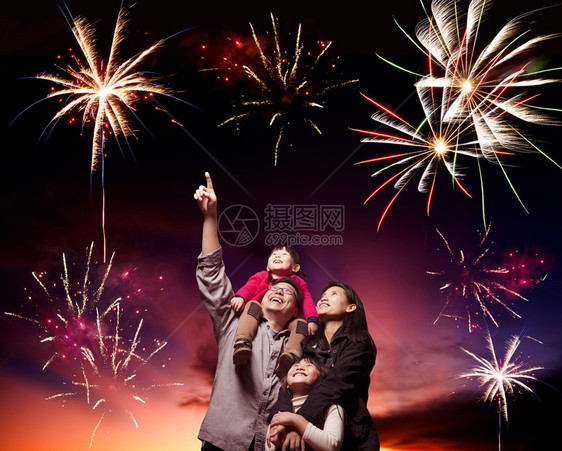 幸福的家庭在傍晚的天空中看烟花图片