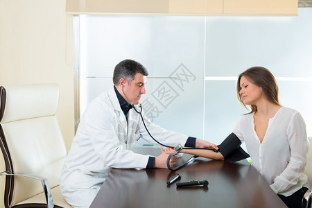 医生男子检查医院办公室女病人手臂的血图片