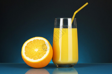 深蓝背景的橙子汁和橙子汁相邻在图片