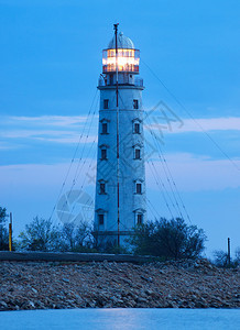 日落后海滩上的灯塔自然的构成图片