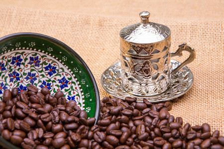 正宗的土耳其咖啡杯配咖啡豆咖啡豆洒在手绘陶图片