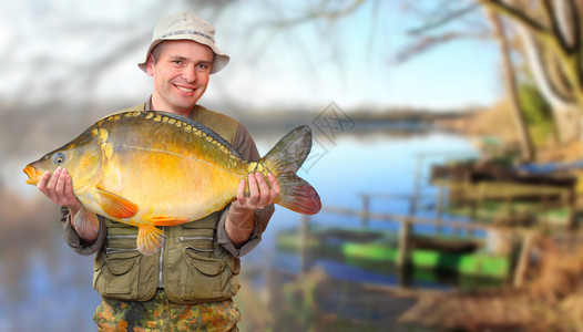 与他在一个美丽的湖在南波西米亚的大鲤鱼渔夫欧洲捷克图片