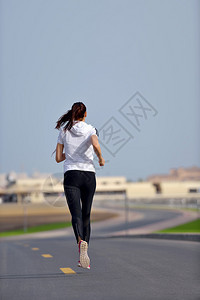女跑者在外边跟迪拜市风景背一起图片