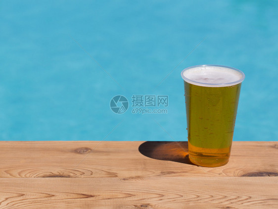 金啤酒啤酒或啤酒杯一个塑料可支配杯子由游泳池图片