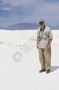高级绅士摄影师在炎热的一天前参观白沙背景图片