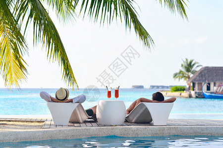 快乐的年轻情侣放松暑假在游泳池后视中图片